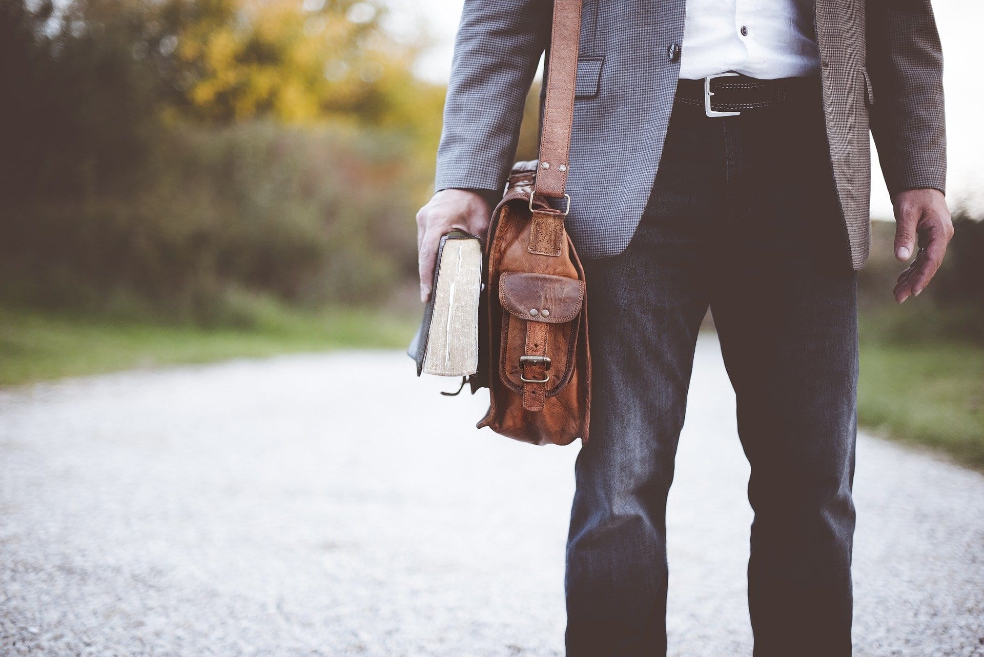 man on path with satchel