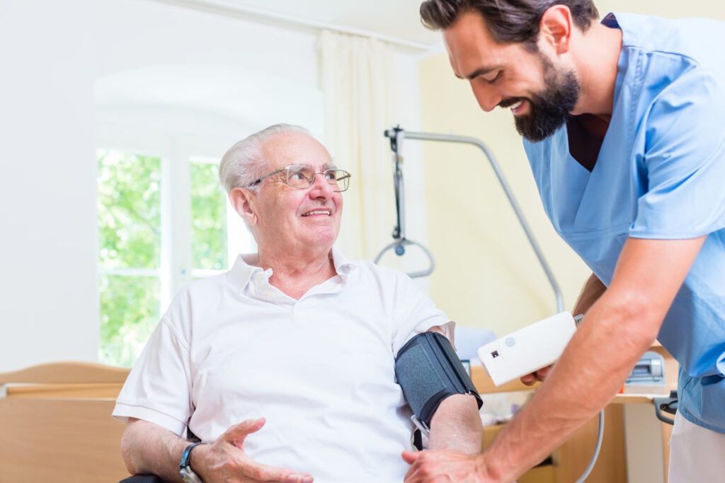 nurse taking elderly mans blood pressure